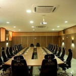 Sound Proofed panelled conference hall with conference table fully equipped with public address system, roll-up projector screen, side board and ,meshed swivel chair with adjustable headrest